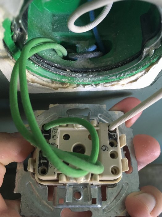 Installation av Wago 222 och doslock i en vägg med synlig grön jordkabel och strömbrytare.