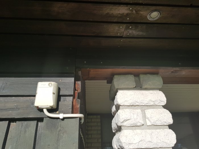 Stolpe samt takstöd med överliggande balk och underliggande staplad stenkolonn som inte når taket.