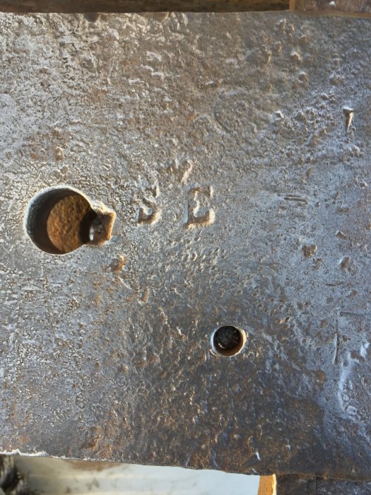 Rostigt skruvstäd med märkningar "SE" och "E Johansson Uppsala 65 lb" synligt på bearbetad yta.