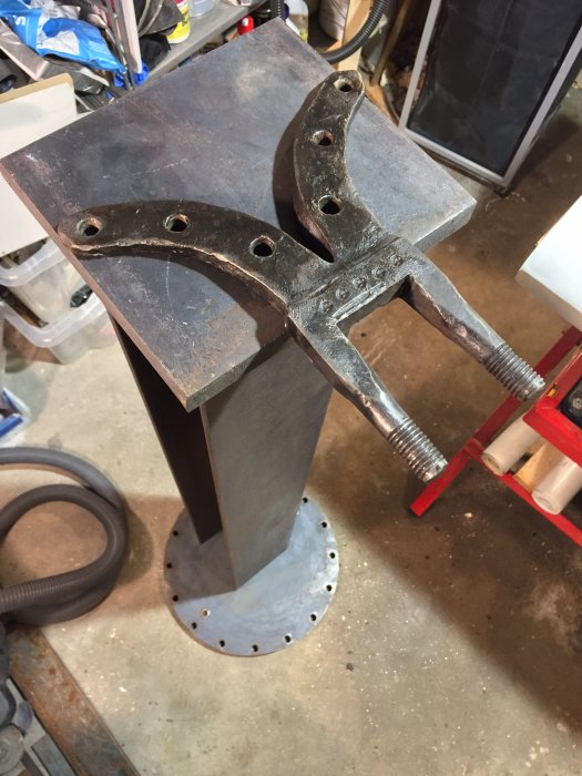 Ett renoverat gammalt skruvstäd monterat på en metallpelare med planfot och designskiss på montering.