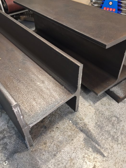 Delar av ett metallstativ på en verkstadsstol i fokus på byggprocessens början.