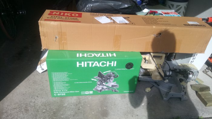 Ny Hitachi gersåg och NIKO ställning oanvända i kartonger på garagegolv.