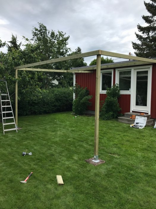Uppbyggnad av trädgårdsaltan i början, med hus och redskap.