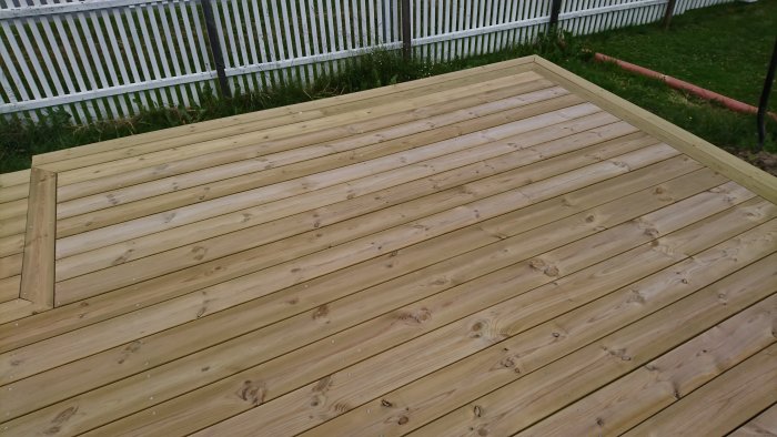 Nybyggt trätrall med sektion avslutad inför midsommar, vit staketbakgrund.