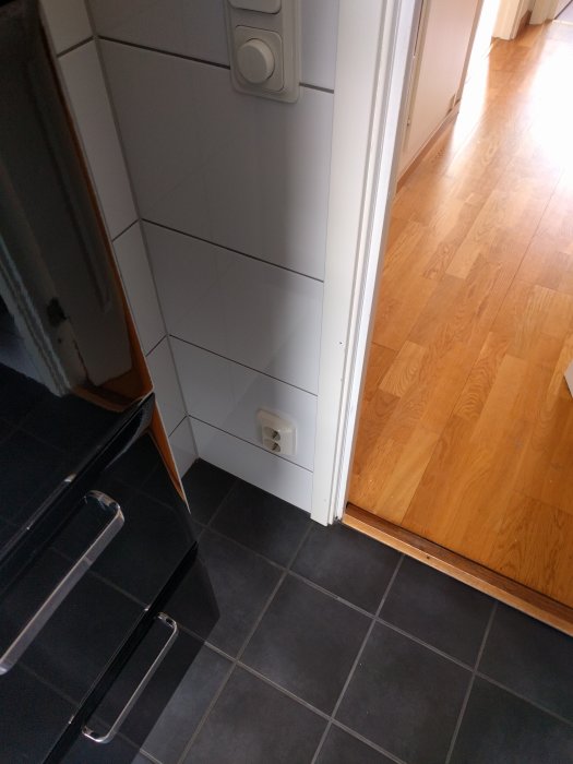 Eluttag nära golv på badrum, potentiell fråga om korrekt installationshöjd och IP-klassificering.