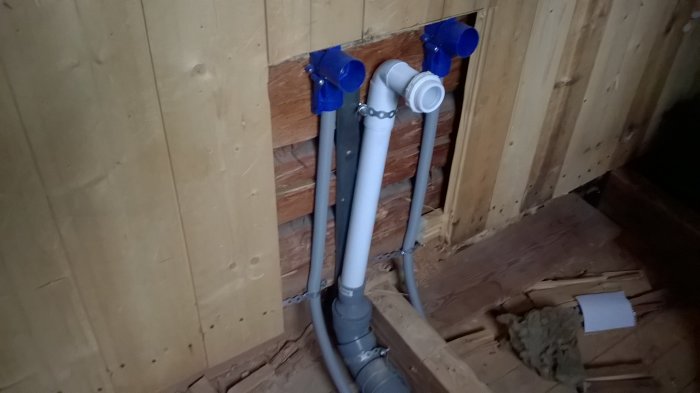 Bild på befintliga träbalkar i hus med järnfäste och vita rör, problem med att fästa nya reglar.