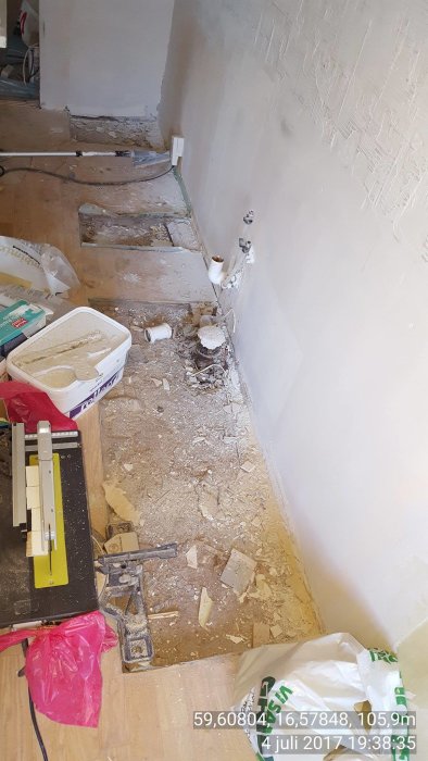 Renoverat kök med borttagna skåp och sandfyllning på golvet som ser ostabilt ut.