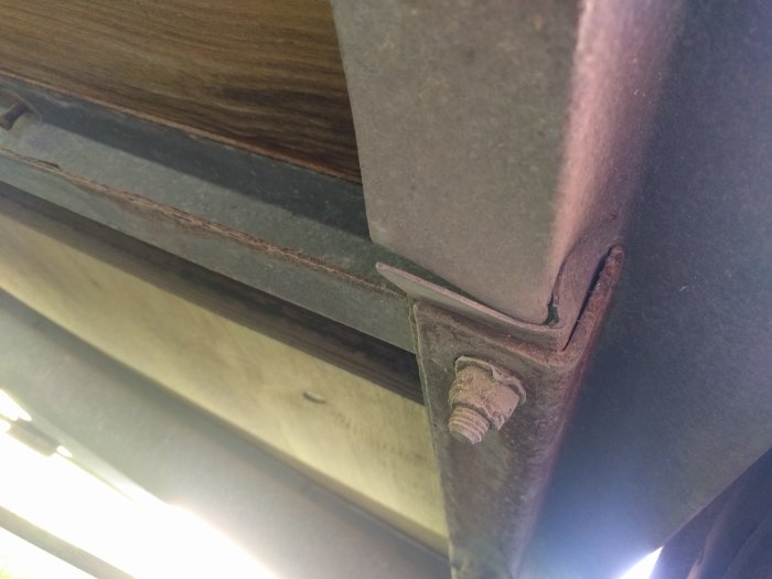 Slitet släpvagnshörn med rost och skadat trä, tecken på två års användning.