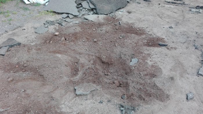 Uppgrävd mark med blandad jord och sten som föreslås omvandlas till bärlager för garageuppfart.