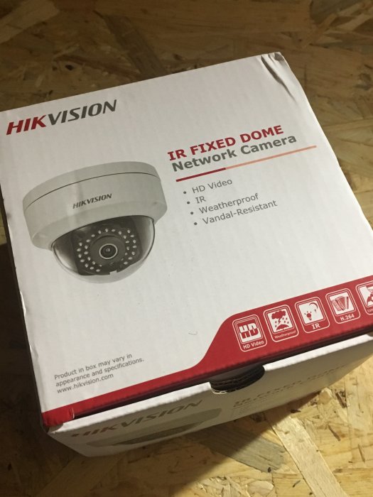 Leverans av en Hikvision IR Fixed Dome Network Camera i originalförpackning på ett trägolv.