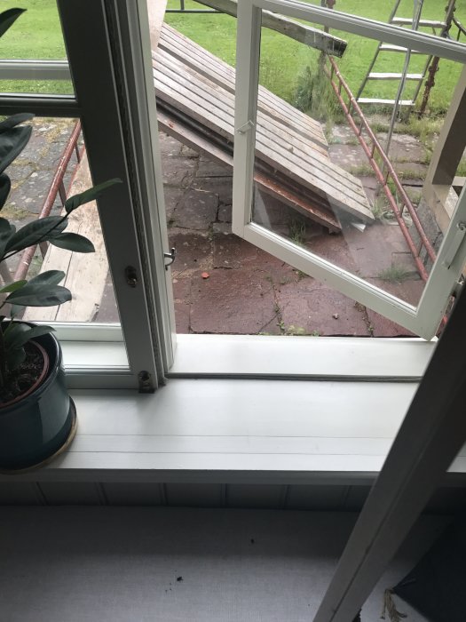 Vy genom öppet fönster som visar innerbågarna lika djupa som ytterbågarna på en altan.