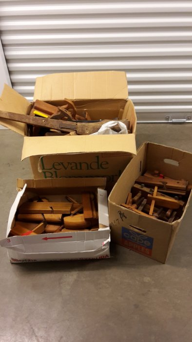 Kartonger fyllda med olika traditionella träbearbetningsverktyg, inklusive trähyvlar och stämjärn.