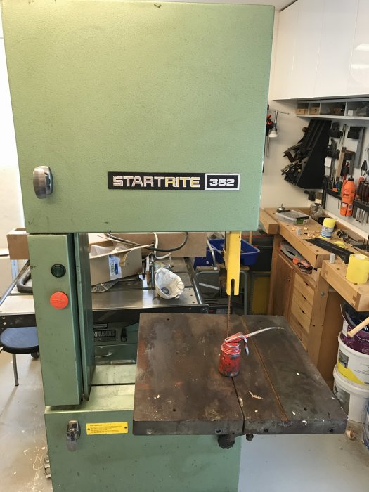 En Startrite 352 bandsåg med utsleten arbetsbeläggning och en oljekanna på arbetsbordet i en verkstad.