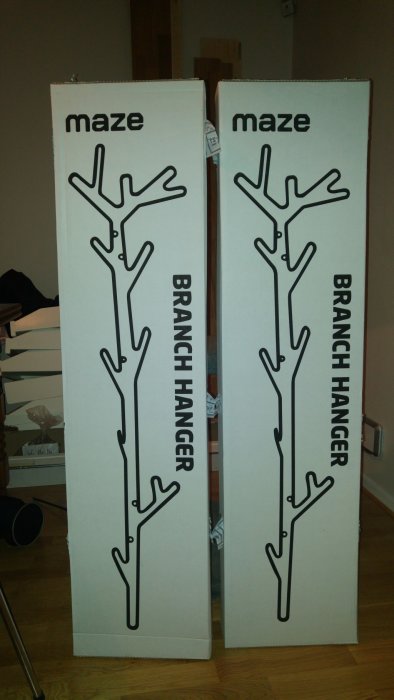 Två lådor med illustrationer av klädhängare formade som grenar, märkta "maze BRANCH HANGER".