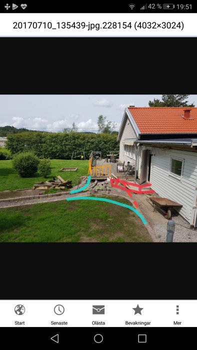 Trädgård med skisserad turkos stenläggning, orange staket och röd trappa ritade på foto av hus.