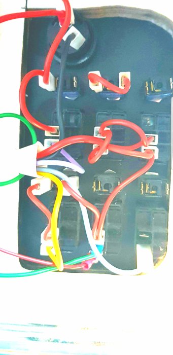 Elpanel med sex brytare och flerfärgade kablar i båt, en pinne halvt intryckt.