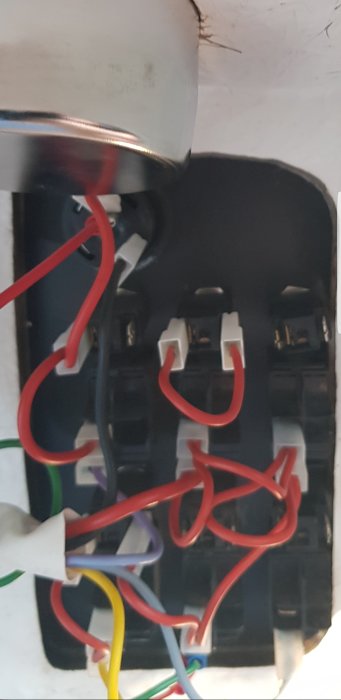 Elektrisk kopplingsbox med färgkodade kablar och terminaler för installation.