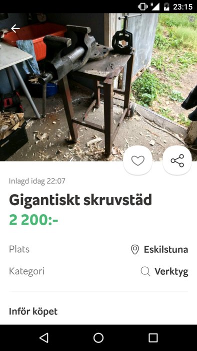 En stor skruvstycke på en verktygsbänk i en verkstad med spån och verktyg synliga.