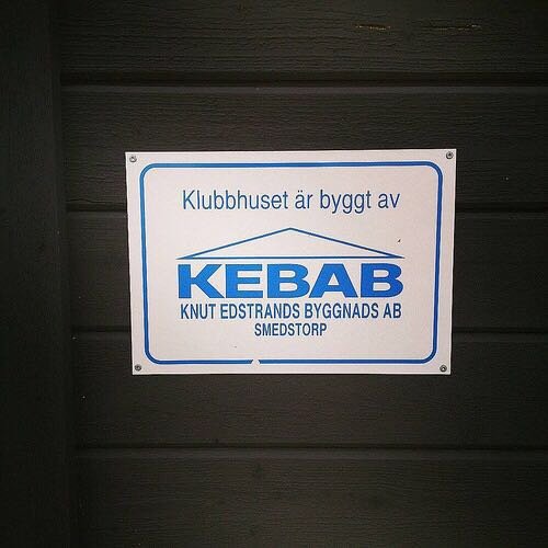 Skylt på vägg med text "Klubbhuset är byggt av KEBAB - KNUT EDSTRANDS BYGGNADS AB SMEDESTORP".