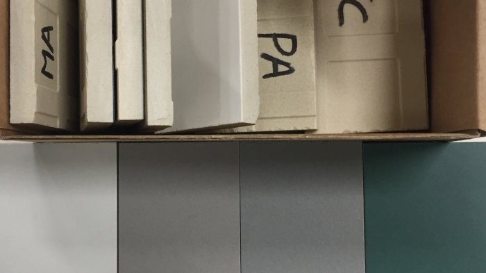 Keramikplattor i förpackning märkt med "PA" mot en grå och grön väggyta.