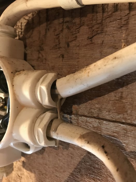 Kabel med skadad och mjuk isolering i en misstänkt överhettad elektrisk koppling mot träbakgrund.