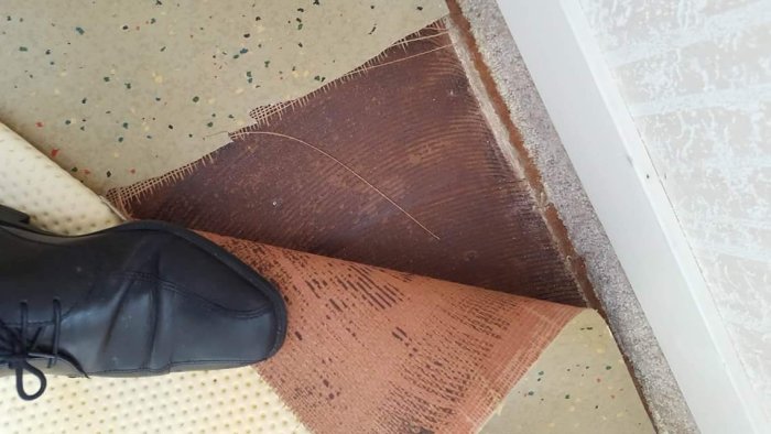 Gammal heltäckningsmatta delvis borttagen från en trappstegskant med synligt limrester och underliggande trägolv.