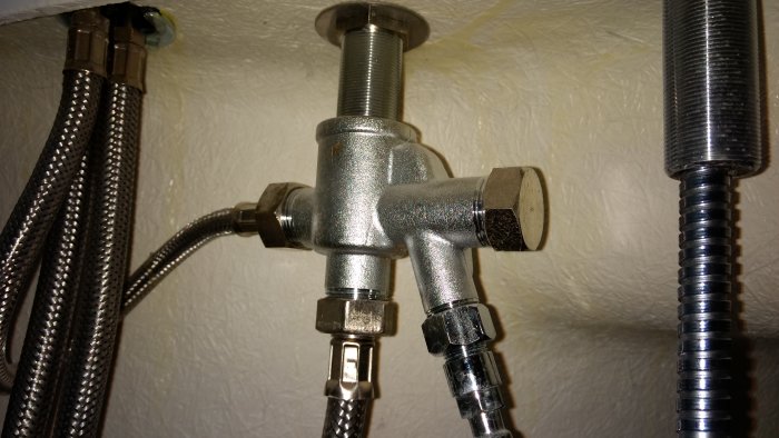 Metallventil som styr vattenflöde till duschslang eller bubbelbadsmunstycken med anslutna slangar.