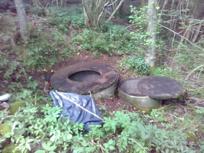 Två betongringar i skogen, använda som tillfällig vattenbrunn och kablageinstallation.