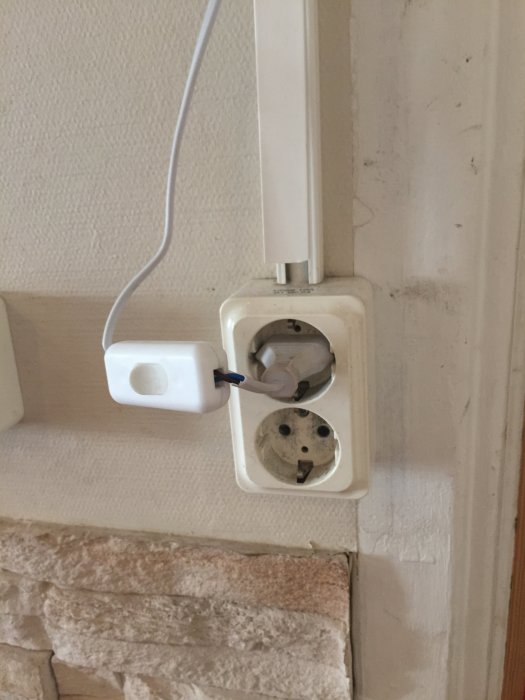 Eluttag med löst hängande kabel och adapter i en restaurang.