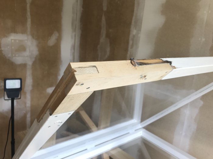 Lagad fönsterbåge med nytt trästycke i rum under renovering.