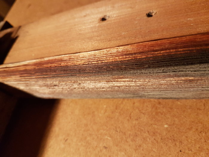 Träkant på ett äldre VELUX takfönster med synliga sprickor och slitage.