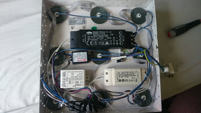 Innandömet i en ljusarmatur med kablar, omvandlare, mottagarbox och etiketterat 'elektronic filter'.