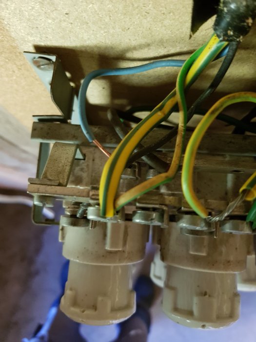 Gamla keramiska säkringar med anslutna färgade kablar i en oanvänd elektrisk central.