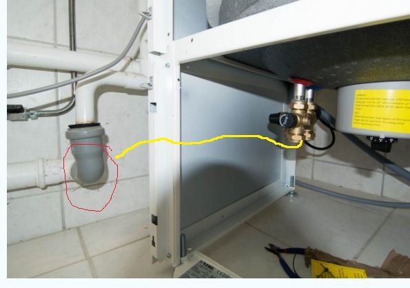 Avloppsrör under diskbänk med T-stycke och vattenledning, markerad väg för potentiell omdragning.