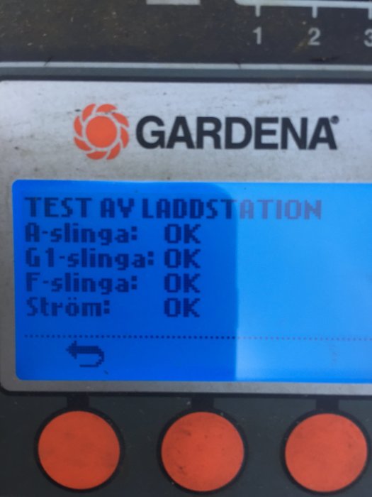 Display på en laddstation med texten "TEST AV LADDSTATION" och resultaten "OK" för olika tester.