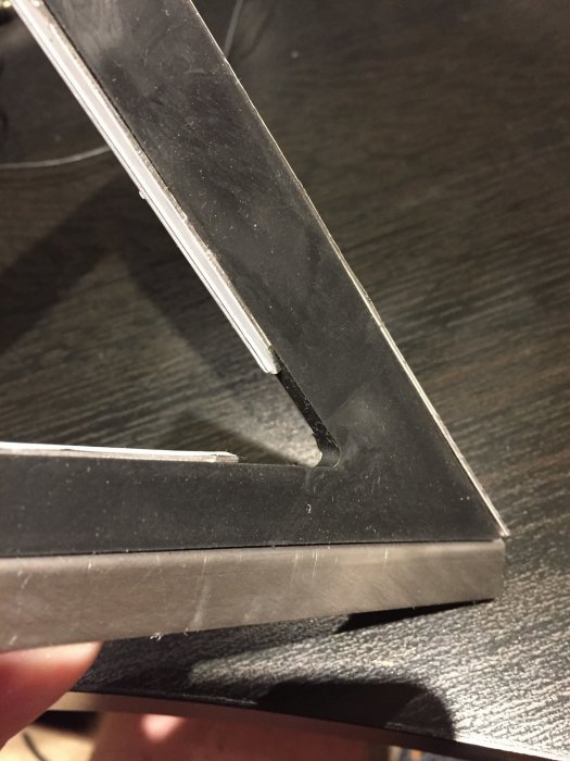 Närbild på en Unidrain hörnbrunnens ram i metall som diskuteras i ett badrumsrenoveringsprojekt.