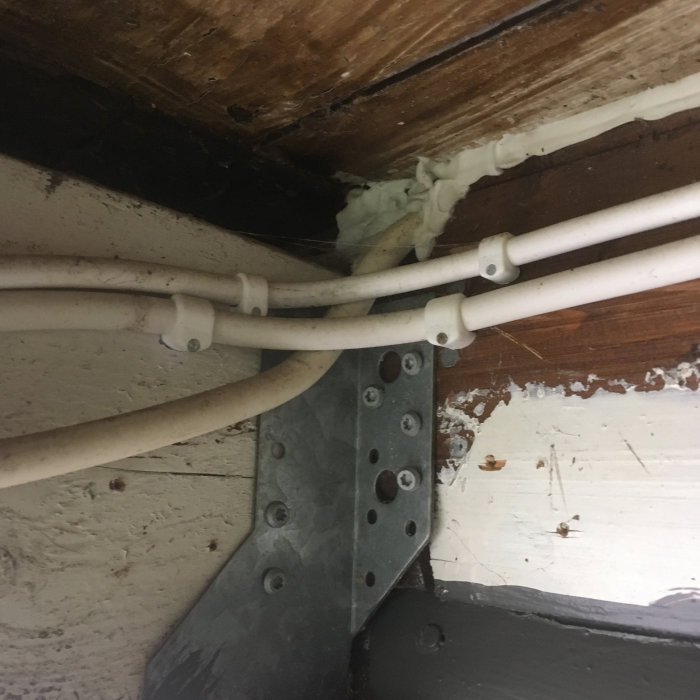 Elrör installerade längs en vägg, några går till en central och andra till ett förråd och strömbrytare.