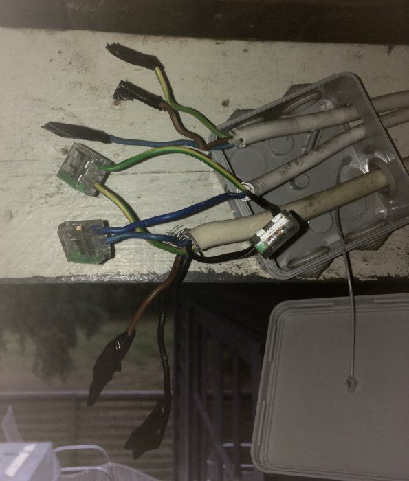 Eluttag som är demonterat med synliga kablar och kontakter mot en vit bakgrund.