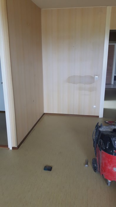 Tomt rum redo för renovering med byggmaterial och verktyg på golvet.