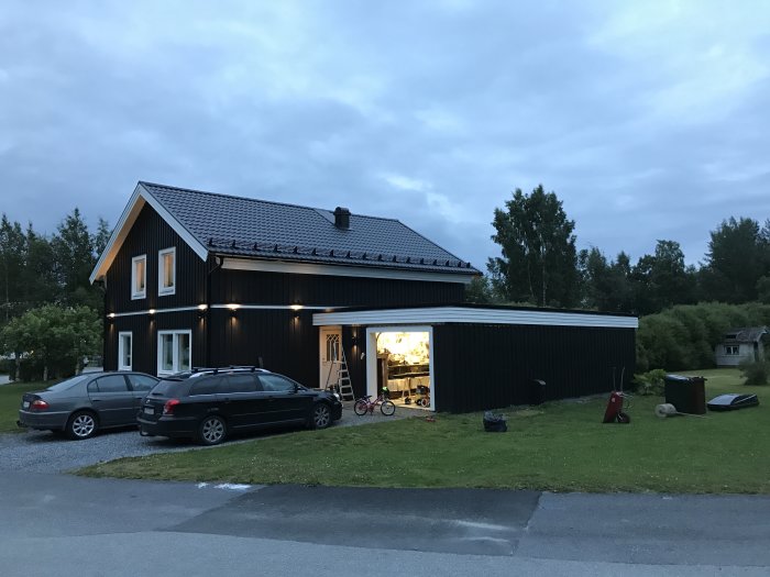 Hus med svagt lutande garagetak och öppen garageport där en bräda tagits bort för kabeldragning.