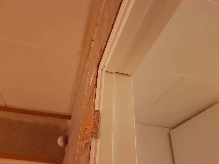 Detalj av taklister och kakel i ett pågående renoveringsprojekt av ett badrum.