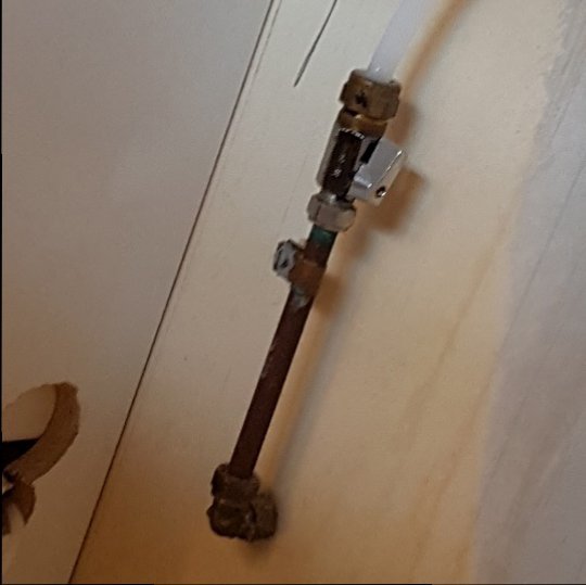 Vattenrör med kopplingar i orenoverat kök, behöver skarvning för diskmaskin.