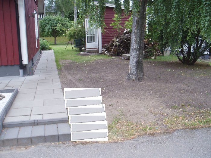 Stenlagd gång och trappa vid hus med förslag på ramp ritad i Paint till höger.