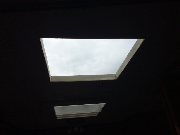 Öppning i husvagnstak efter montering av aircondition, utsikt mot himlen genom fyrkantigt hål.