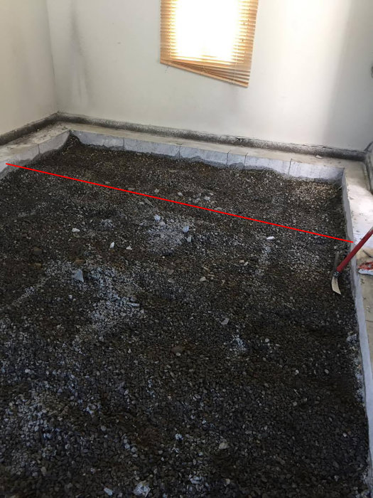 Garage med urgrävd betongplatta och kvarvarande betongkant längs väggarna för stabilitet.