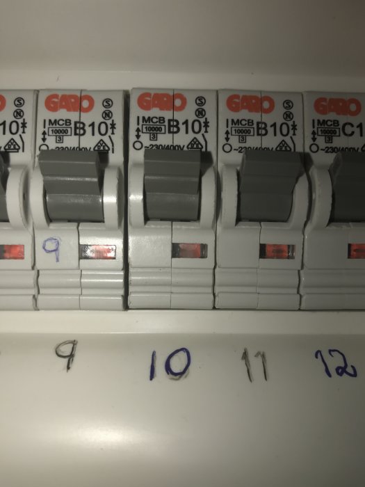 Elektrisk säkringspanel med säkringar märkta B10 och numrerade med handskrift 9 till 12, fokus på nummer 10.