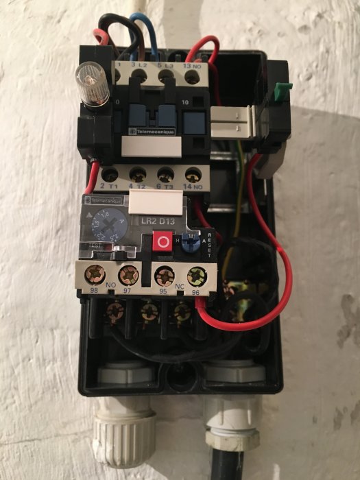Elektriskt motorskydd och kontroller av märket Telemecanique monterade på en vägg, med justeringsratten ställd på 1,8 A.
