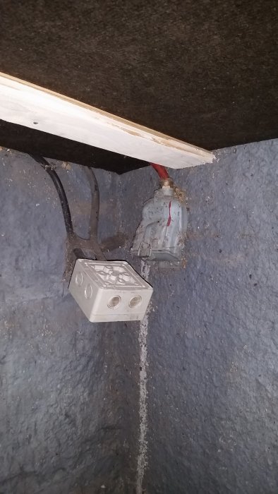 Kabelskarvning och 3-fas uttag installerat i en källares betongvägg.