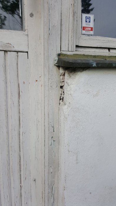 Skadad puts på hålbetong vid fönsterkarm med sprickor och släppande material.