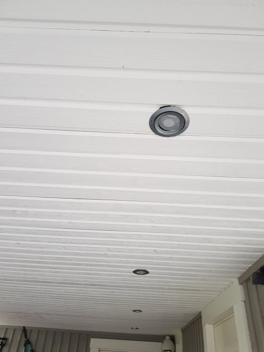 Vit paneltak med inbyggda spotlights på en veranda.